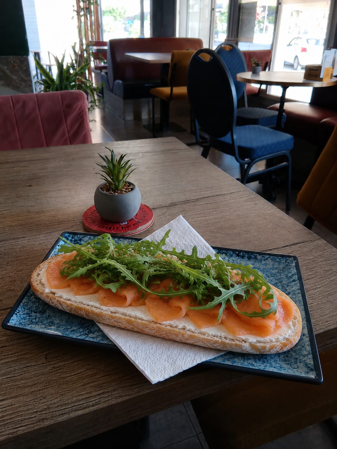 Tostada de Philadelphia con salmón y rúcula en plato azul